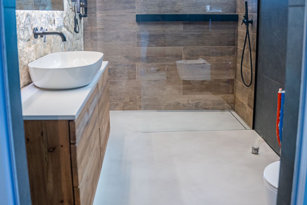 Beton pod prysznicem - surowa elegancja i trwałość w nowoczesnej łazience.