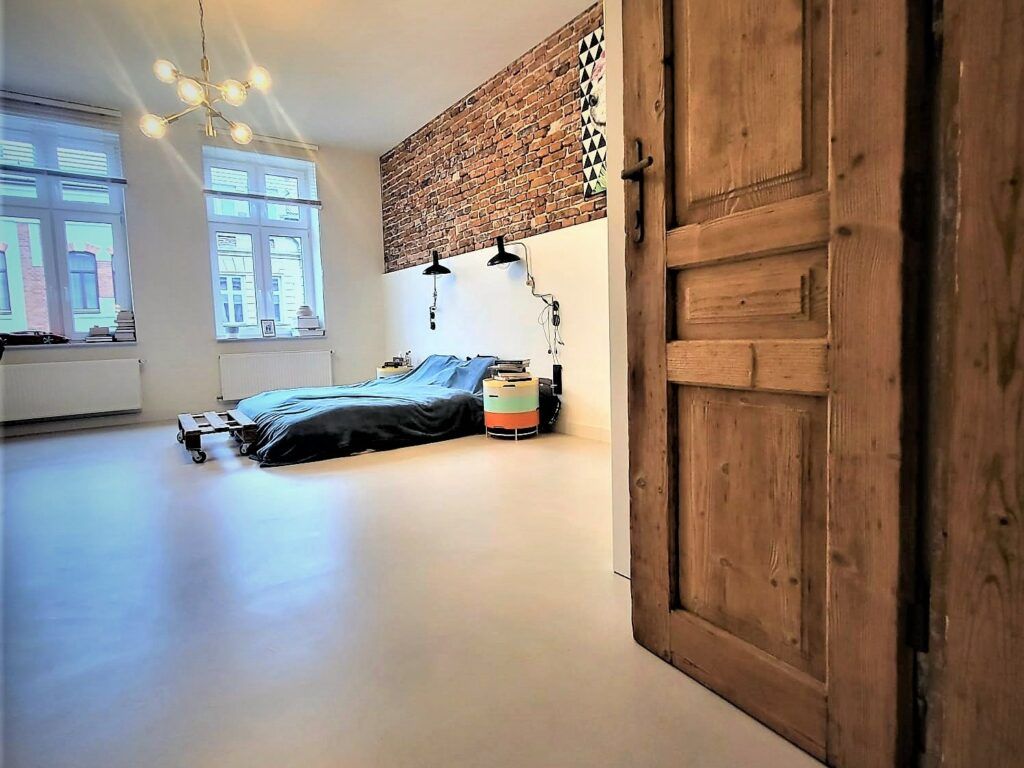 Mikrocement w sypialni - nowoczesne wykończenie mieszkania, optycznie powiększające przestrzeń.