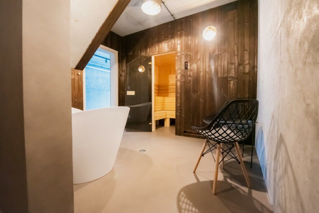 Łazienka i sauna w nowoczesnym mieszkaniu z mikrocementem - elegancja i trwałość w jednym.