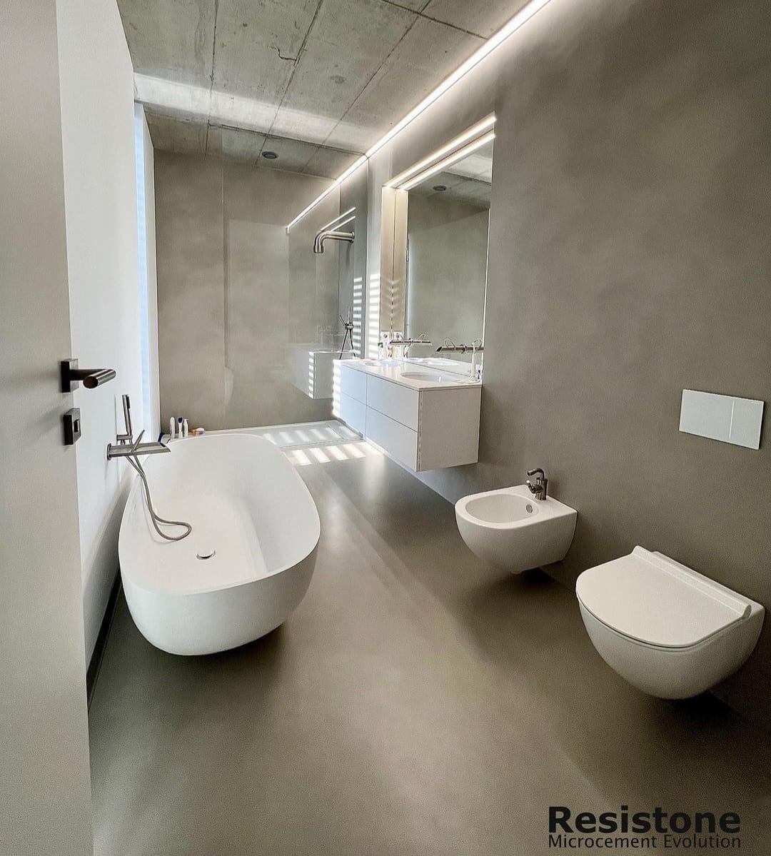Inspiracje łazienka - Minimalistyczna łazienka z mikrocementem na ścianach i podłodze, utrzymująca elegancki i prosty design.